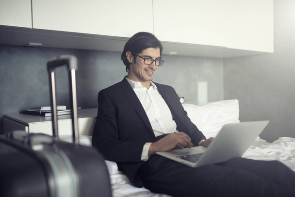 旅行の準備のビジネスマンは彼のノート パソコンで動作します。 - 写真・画像