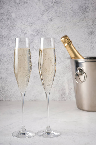 iki kadeh şampanya ile bir kova içinde şampanya şişesi - Fotoğraf, Görsel
