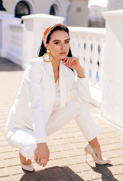 beautiful woman with dark hair in elegant white suit and accesso - Photo, image