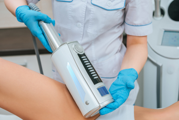Cropped view of cosmetologist doing endospheres therapy for leg - Foto, Bild