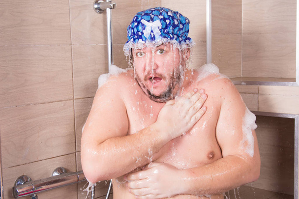Un homme gras et drôle chante dans la douche. - Photo, image