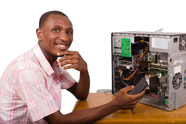 jovem trabalhador africano em serviço reparando um desktop
 - Foto, Imagem