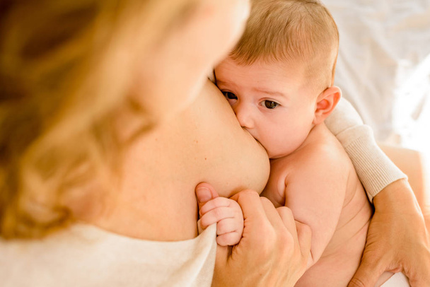 Мать кормила грудью младенца в постели тихо по утрам, здоровье
 - Фото, изображение