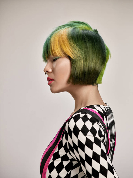Close-up indoor portrait of lovely girl with colorful hair. Studio shot of graceful young woman with short haircut - Photo, Image