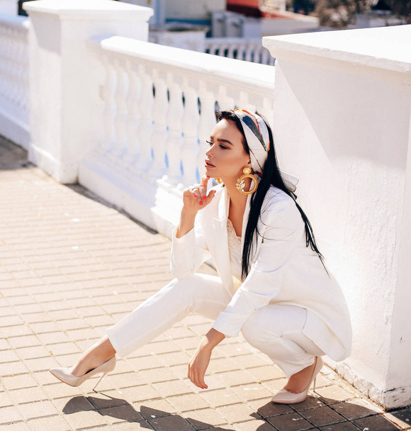 beautiful woman with dark hair in elegant white suit and accesso - Valokuva, kuva