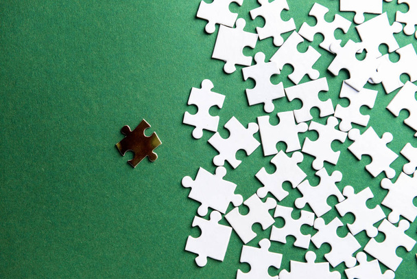 Golden puzzle piece among white ones on color background. Concept of uniqueness - Photo, Image