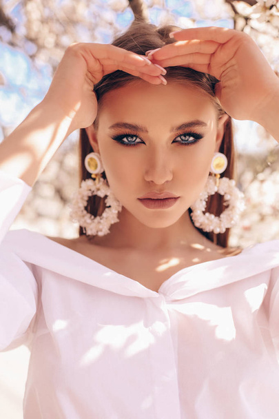 beautiful young woman in elegant dress and luxurious earrings po - Fotó, kép
