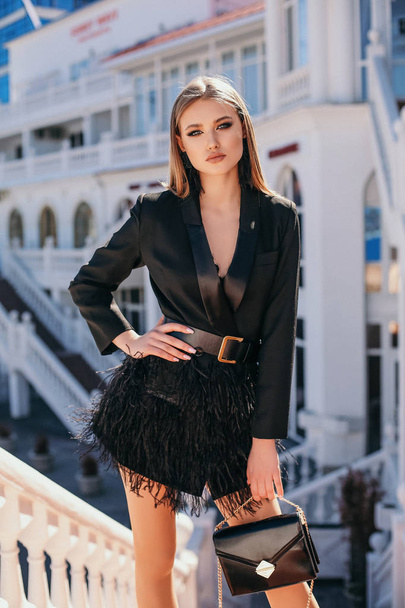 beautiful woman with blond hair in elegant outfit walking by the - Foto, afbeelding