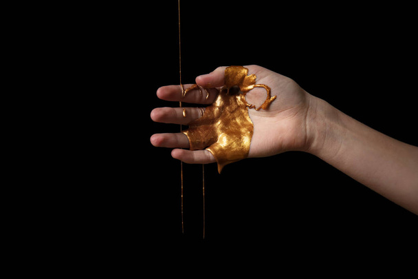 Жіноча рука з фарбою на темному фоні
 - Фото, зображення