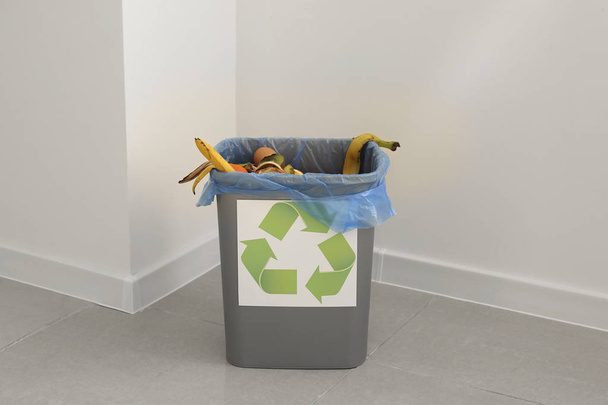 Trash bin with garbage indoors - Foto, afbeelding