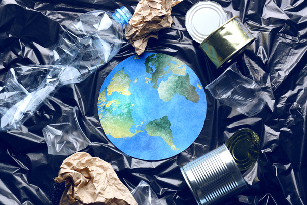 Бумажная фигура земли и мусора на полиэтиленовой пленке. Концепция охраны окружающей среды
 - Фото, изображение