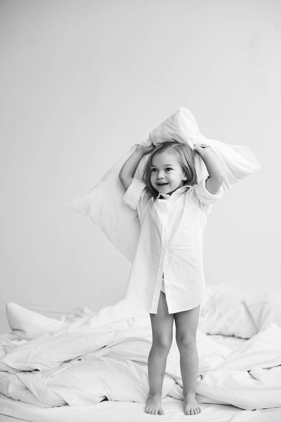 A portrait of beautiful little girl in the morning bedroom - Zdjęcie, obraz