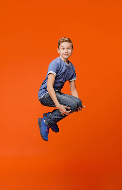 Cheerful school boy jumping in bomb style - Foto, immagini