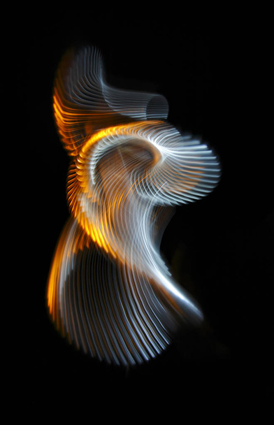 Multicolored twisted ordered parallel lines on a black background. Light in motion. Color abstraction. - Photo, image