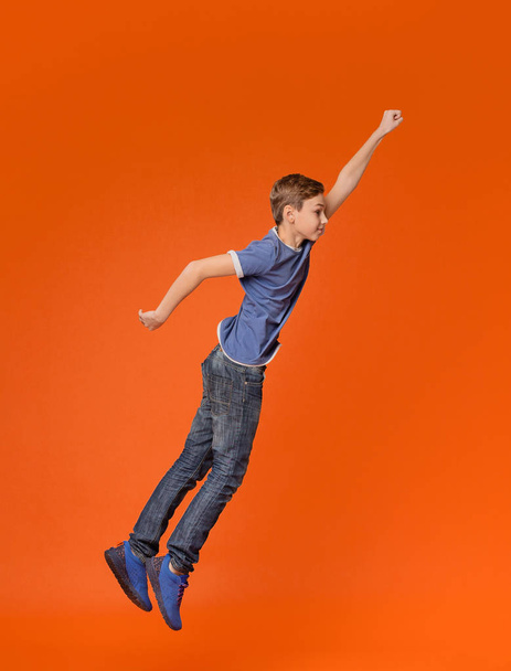 Mały chłopiec skoki z podniesiona pięść jak superbohater - Zdjęcie, obraz