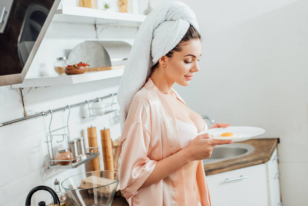 Mujer sexy en la placa de retención de la avena con huevo frito en la cocina
 - Foto, Imagen