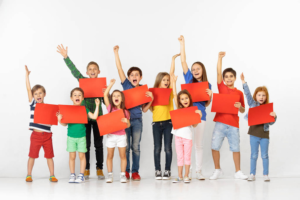 Group of children with a red banners isolated in white - Foto, afbeelding