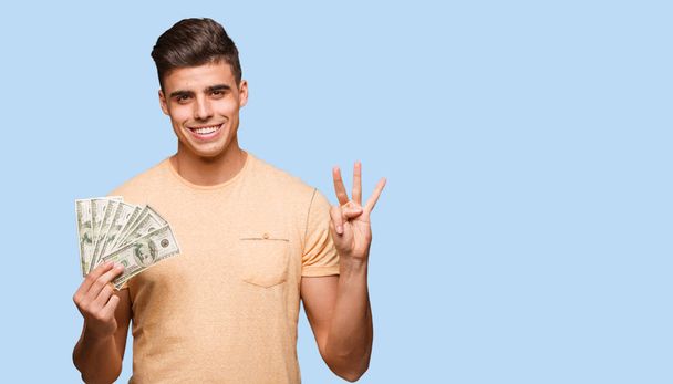 Νεαρός άνδρας δολάρια χαρτοφυλακίου δείχνει αριθμός τρία - Φωτογραφία, εικόνα