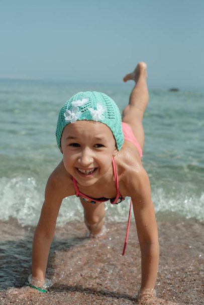Cute little girl playing at shore on sea background  - Foto, Bild