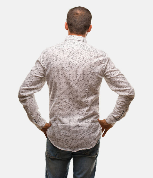 Homme caucasien sur fond gris par derrière, regardant en arrière
 - Photo, image