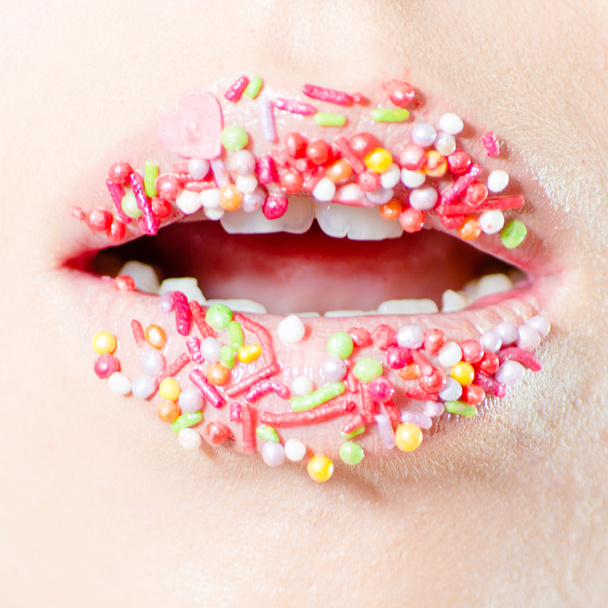 Closeup on female sweet candy lips with licking tongue - Photo, Image