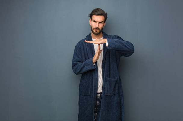 Man wearing pajama doing a timeout gesture - 写真・画像