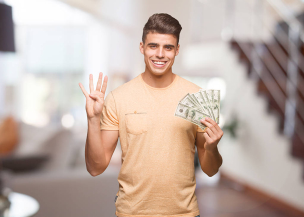 Mladý muž hospodářství dolarů zobrazující číslo čtyři - Fotografie, Obrázek