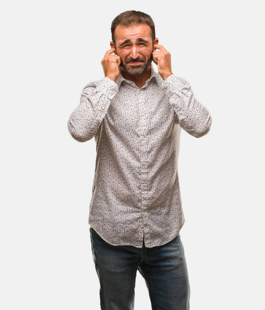 Hombre caucásico sobre soporte gris cubriendo las orejas con las manos
 - Foto, Imagen