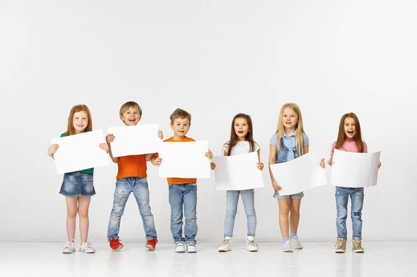 Group of children with a white banners isolated in white - Fotó, kép