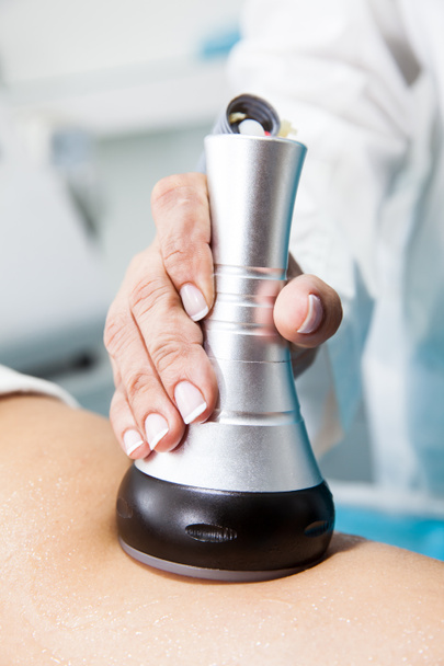 Médecin effectuant un traitement d'ultracavitation sur une jeune jambe patiente
 - Photo, image