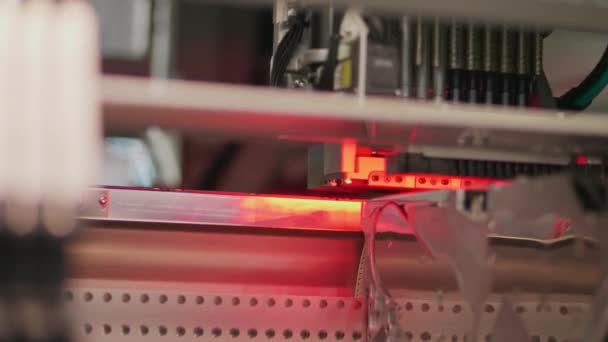 Elektroninen piiri pinta-asennus kone punainen valo, alhaalta katsottuna. Pinta-mount teknologia tuottaa elektronisia piirejä. Painettujen elementtien pinnalle sijoitetut komponentit. Automaattinen komponenttien kerääminen robottilaitteella
. - Materiaali, video