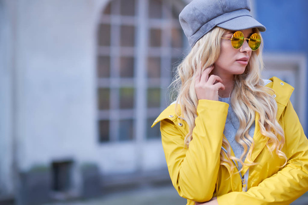Blonde girl in a yellow raincoat - Fotoğraf, Görsel