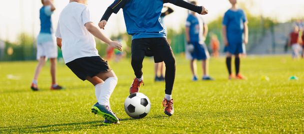 Boy kicking soccer ball. Close up action of boys soccer teams, aged 8-10, playing a football match - Photo, image