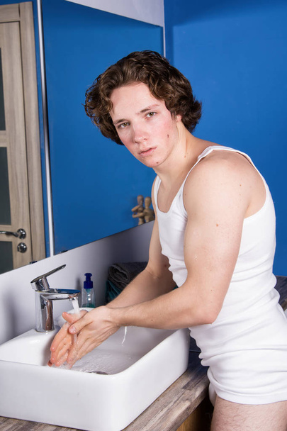 Πλύνε τα δόντια σου. Νεαρός ελκυστικός άντρας στο μπάνιο. - Φωτογραφία, εικόνα