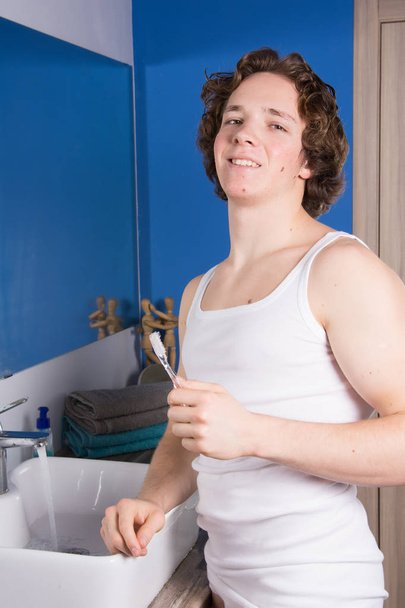 Mosd meg a fogad. Fiatal vonzó srác a fürdőszobában. - Fotó, kép