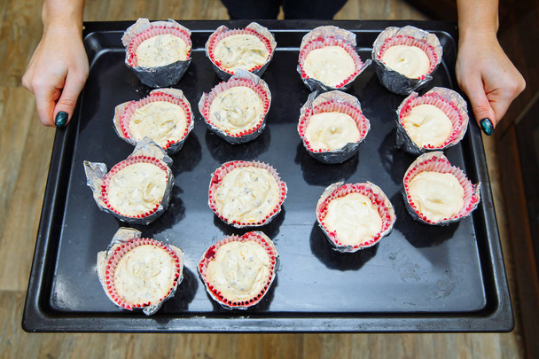 Cooking cupcakes at home. Cheesecakes on the baking sheet - Foto, afbeelding