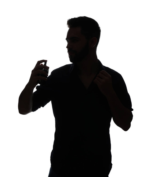 Silueta de hombre guapo con botella de perfume sobre fondo blanco
 - Foto, imagen