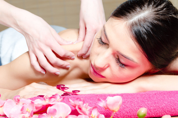 Красива жінка розслабляється під час масажу з квітами, ідеальна шкіра
 - Фото, зображення