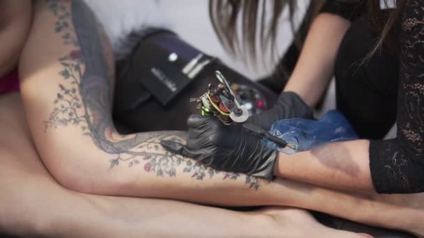 Γυναίκα τατουάζ πλοίαρχος κάνει ένα τατουάζ σε μια γυναίκα. - Πλάνα, βίντεο