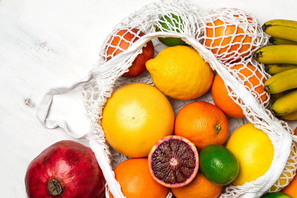 Organic citrus fruits variety in cotton mesh reusable shopping b - Foto, imagen