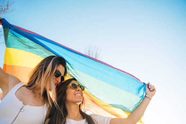 Pár leszbikus nő meleg büszkeség zászló az utcán - Fotó, kép
