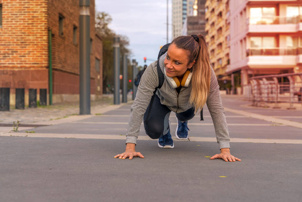 An athletic woman stretching on the street - Фото, зображення