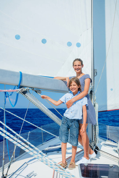 Boy with his sister on board of sailing yacht on summer cruise. - Fotoğraf, Görsel