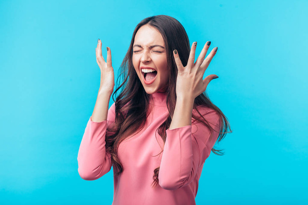 Excited screaming beautiful woman portrait on blue background - Fotoğraf, Görsel