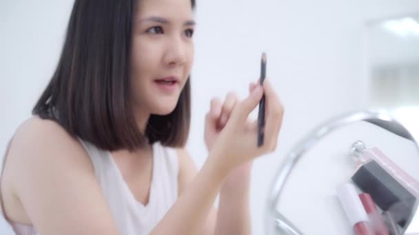 Beauty-Blogger präsentieren Schönheitskosmetik, die vor der Kamera sitzt, um Videos aufzunehmen. glücklich schöne junge asiatische Frau verwenden Kosmetik Bewertung Make-up-Tutorial übertragen Live-Video auf soziale Netzwerke. - Filmmaterial, Video