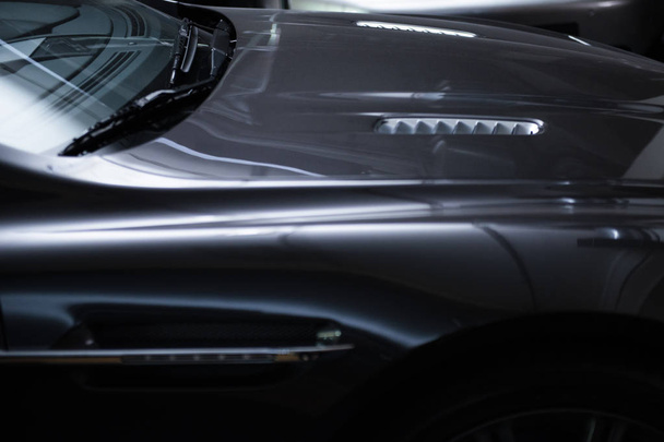 Achteraan koplamp van een moderne luxe grijs rode metalen auto, auto detail, auto onderhoud concept in de garage - Foto, afbeelding