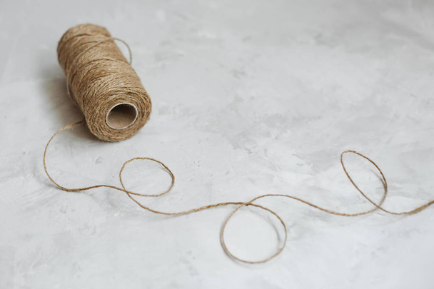 Linen thread spool on a textured gray background - Fotó, kép