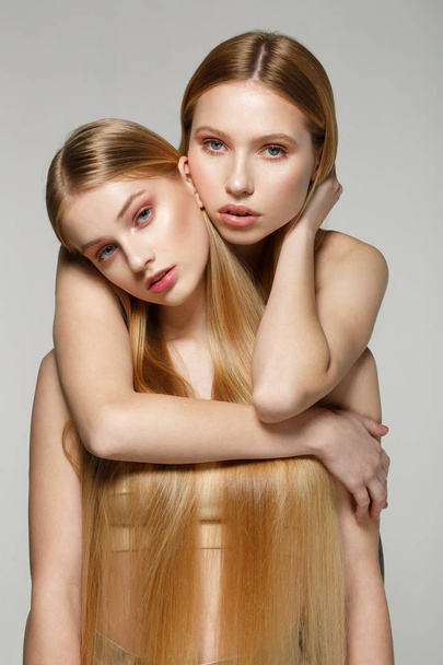 Fashion lifestyle portrait of two pretty friends girls with amazing blonde hair, perfect skin - Photo, Image