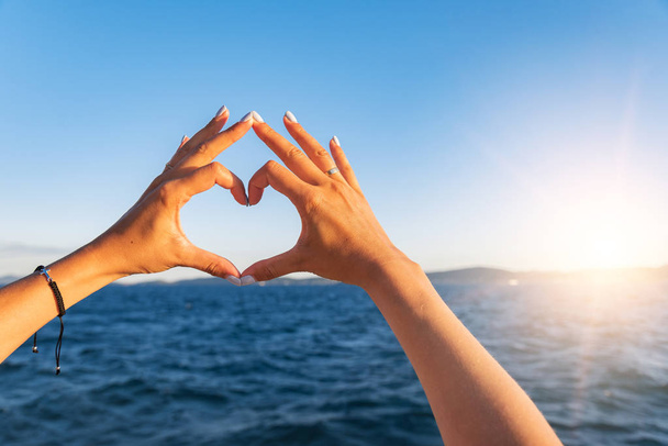 Jovens belas mãos femininas no fundo do mar mostram o símbolo do coração. Férias - conceito
. - Foto, Imagem