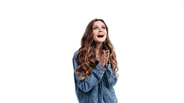 Веселая молодая женщина хлопает и смеется в студии
 - Фото, изображение